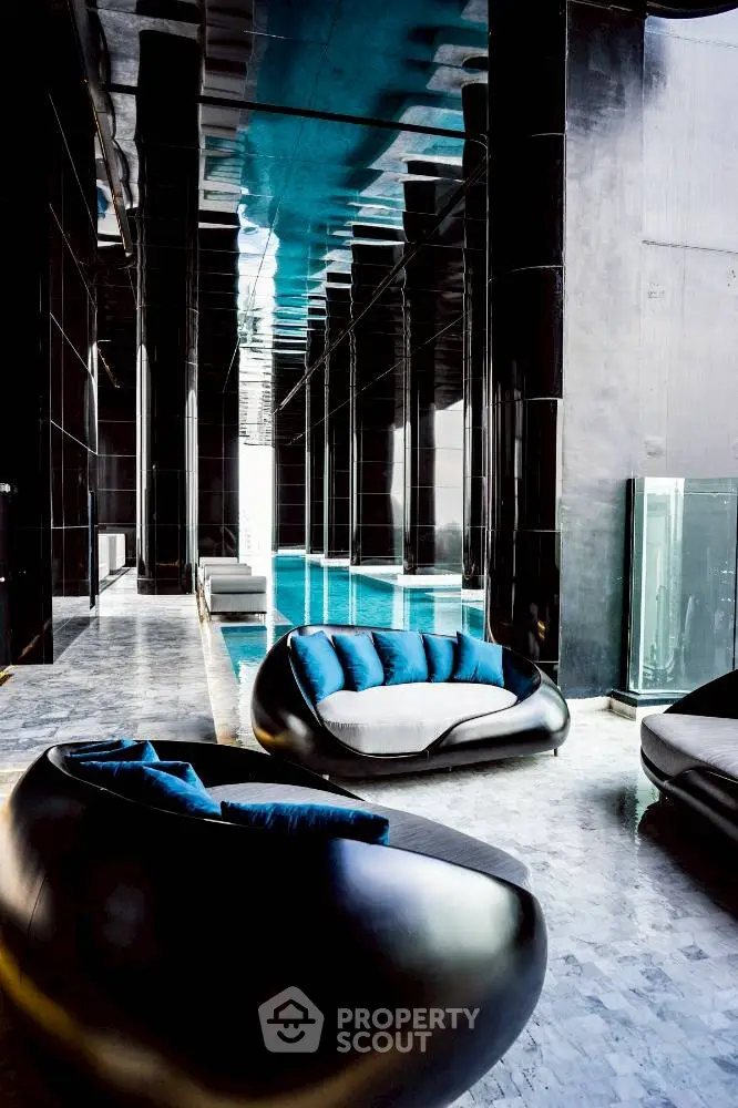 Luxurious indoor pool area with modern seating and sleek black design.