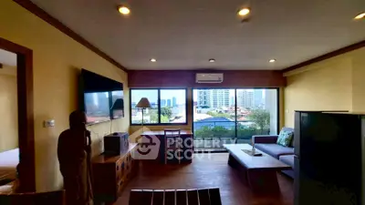 Spacious living room with city view, modern furniture, and large windows for natural light.