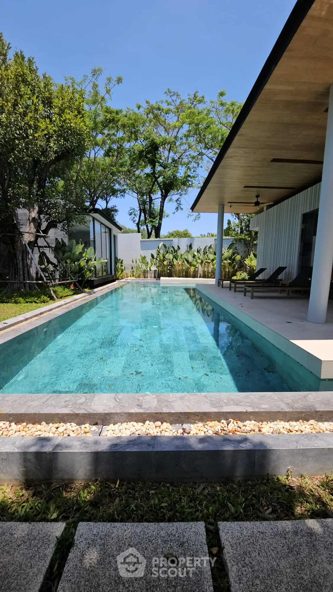 Luxurious modern villa with stunning private pool and lush greenery, perfect for relaxation and entertainment.