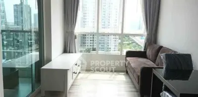 Modern living room with large windows and city view, featuring a cozy sofa and sleek furniture.