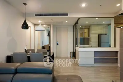 Modern open-plan living room with sleek furniture and contemporary lighting in a stylish apartment.