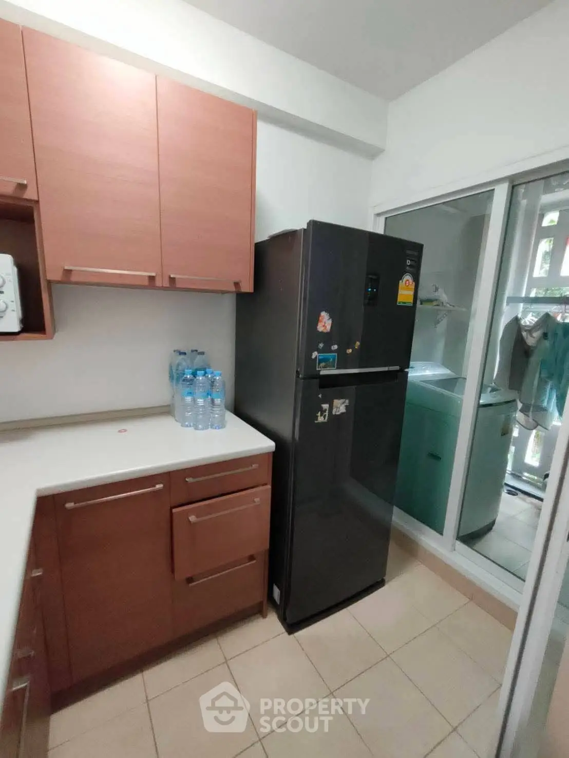 Modern kitchen with sleek black fridge and ample storage space