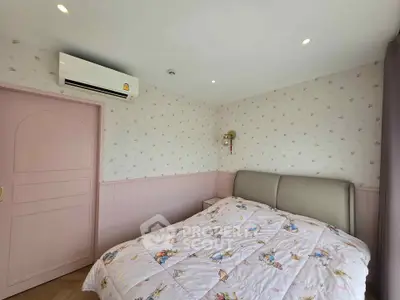 Charming bedroom with pastel decor and cozy bedding, featuring a wall-mounted air conditioner for comfort.
