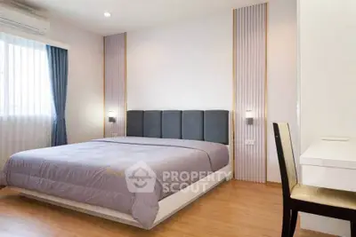 Modern bedroom with stylish decor and natural light, featuring a comfortable bed and sleek furnishings.