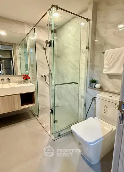 Modern bathroom with glass shower and elegant fixtures in luxury apartment.