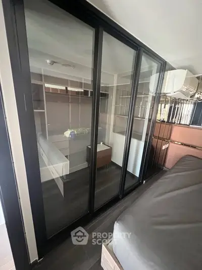 Modern bedroom with glass sliding doors and sleek storage solutions