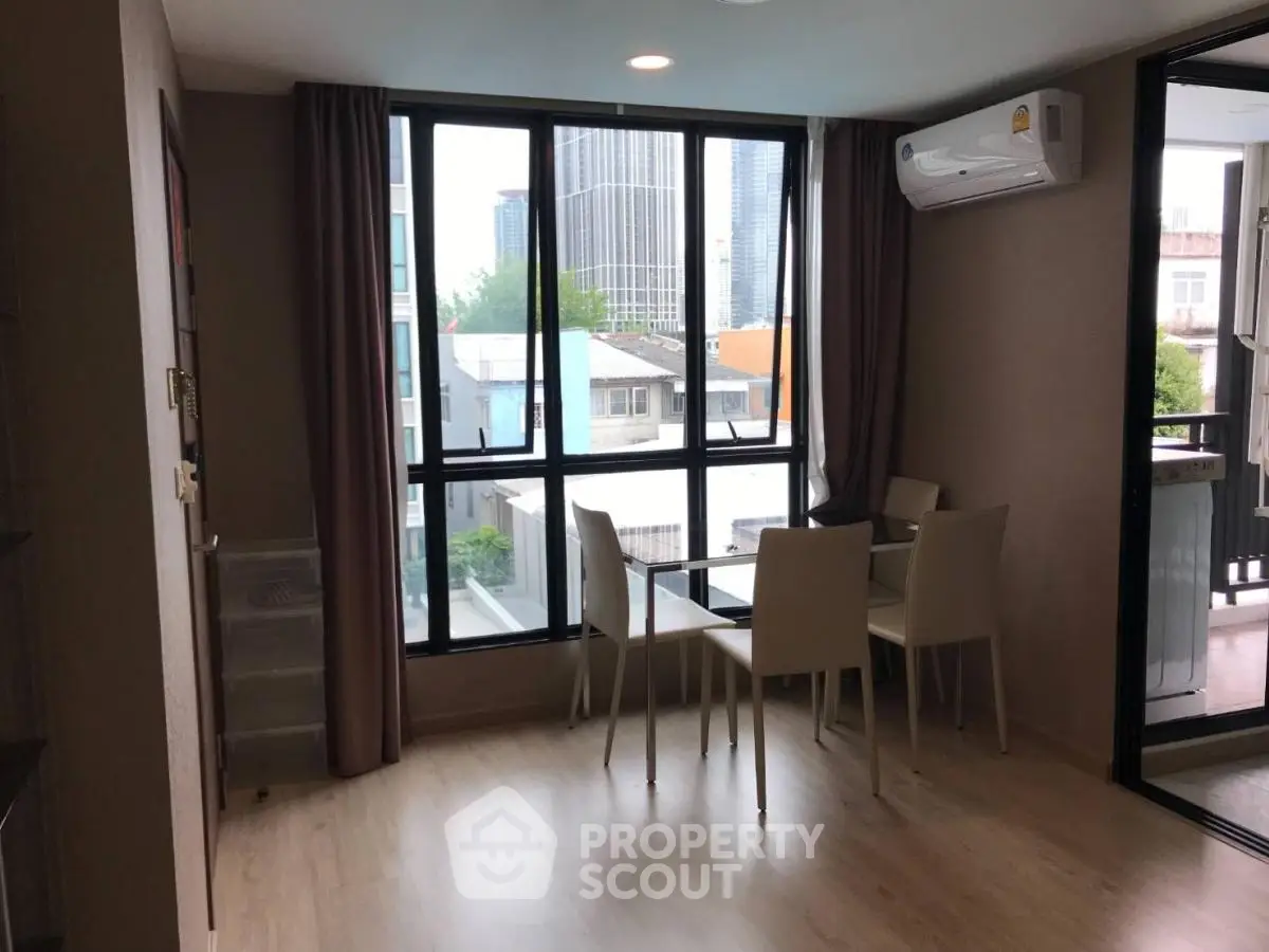 Modern living room with large windows and dining area in urban apartment