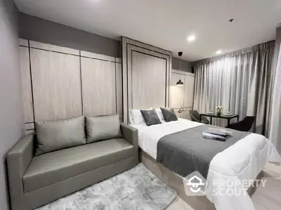 Modern bedroom with stylish decor and cozy seating area in a luxurious apartment.