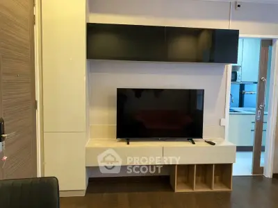 Modern living room with sleek TV unit and open kitchen view