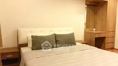 Spacious bedroom with modern wooden furniture and cozy bedding in a stylish apartment.