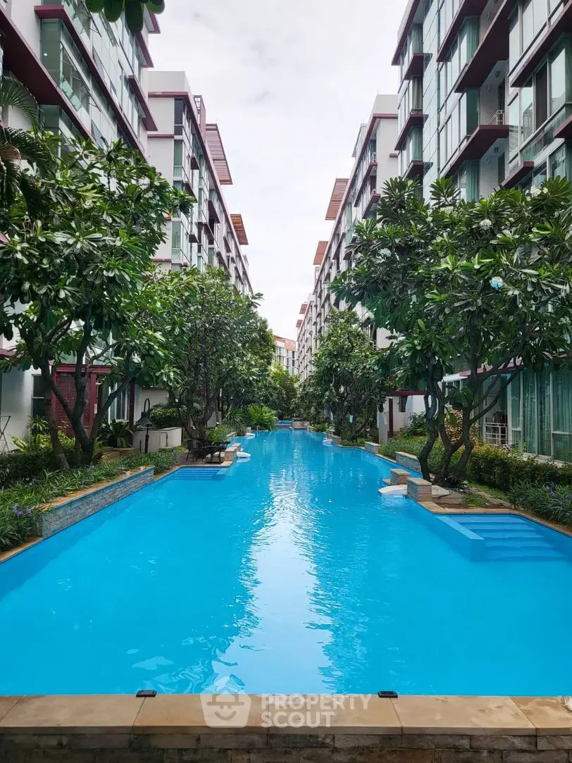 Luxurious residential complex with stunning outdoor pool and lush greenery.
