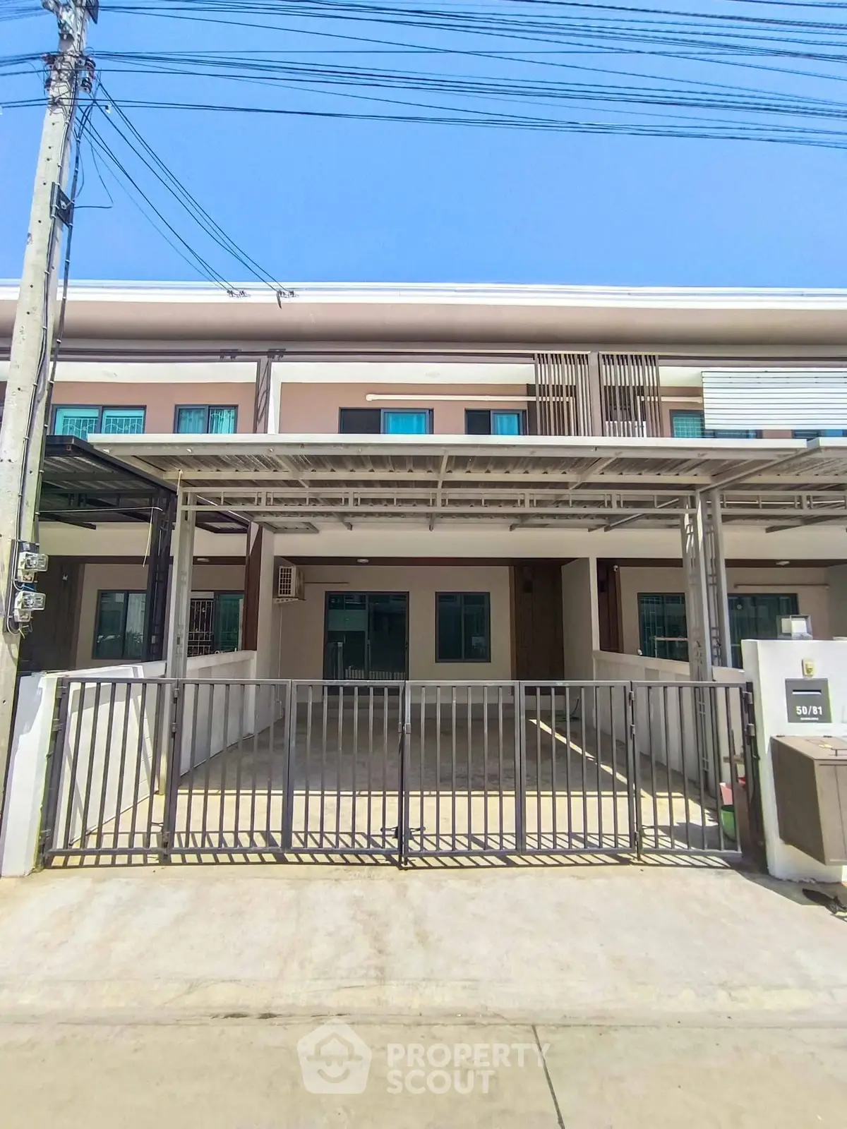 Modern townhouse with gated parking and sleek exterior design in a suburban neighborhood.