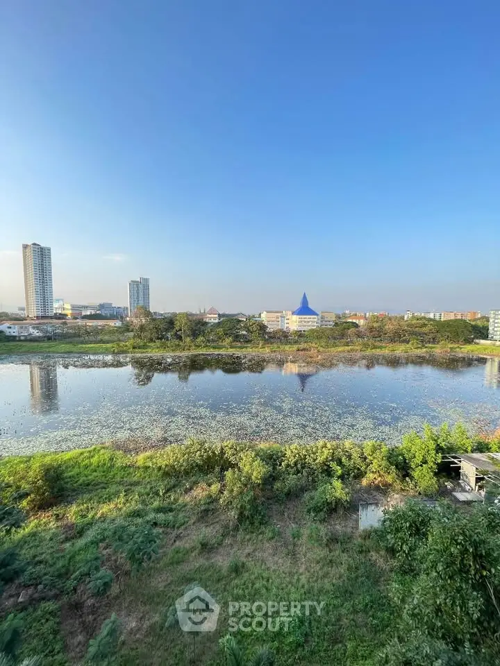 Stunning cityscape view with serene water body and lush greenery, perfect for tranquil living.