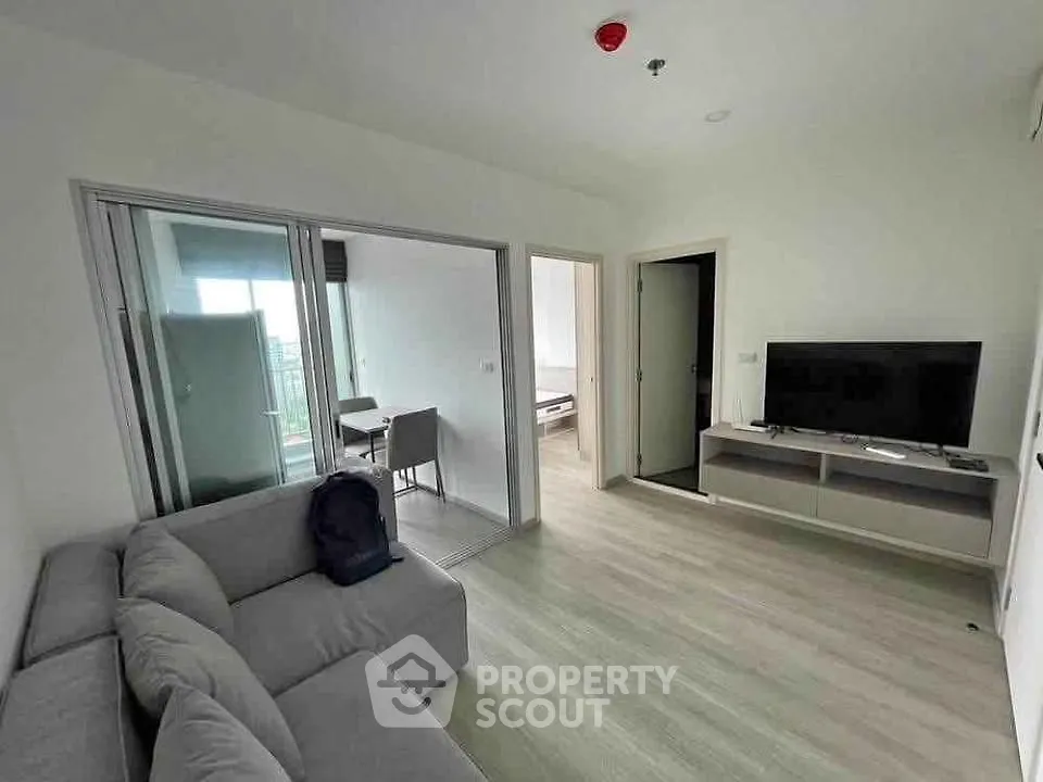 Modern living room with sleek furniture and open balcony view in a stylish apartment.