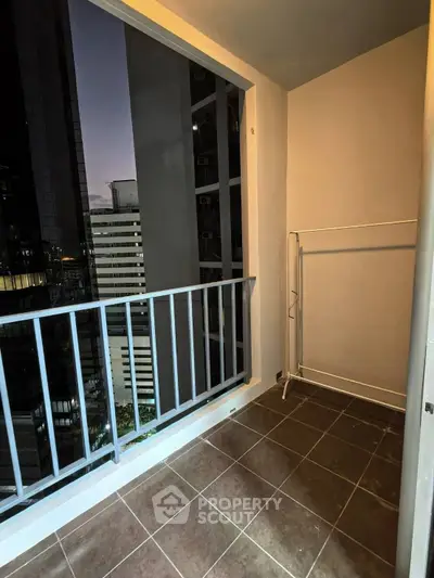 Cozy balcony with city view, perfect for relaxing evenings in a modern high-rise apartment.