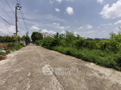 Spacious plot of land with lush greenery and clear sky, ideal for development.