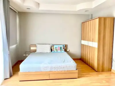 Spacious bedroom with modern wooden furniture and natural light