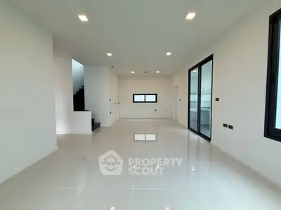 Spacious modern living room with sleek tile flooring and large windows.