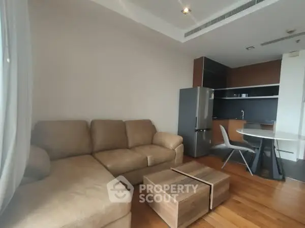 Modern living room with cozy sofa and sleek kitchen area, perfect for urban living.
