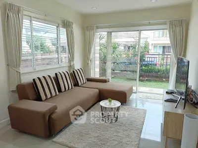 Spacious living room with modern decor and garden view, perfect for relaxation.