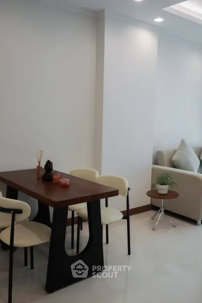 Modern dining area with sleek table and cozy seating in a stylish apartment.