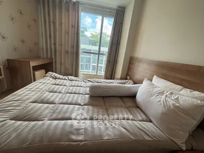 Cozy bedroom with large window and modern decor in a stylish apartment.