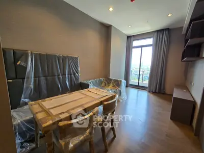 Modern living room with large window and new furniture in a high-rise apartment.