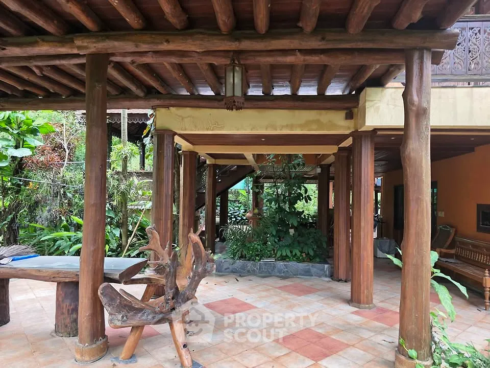 Charming rustic outdoor patio with wooden beams and lush greenery, perfect for relaxation and entertaining.