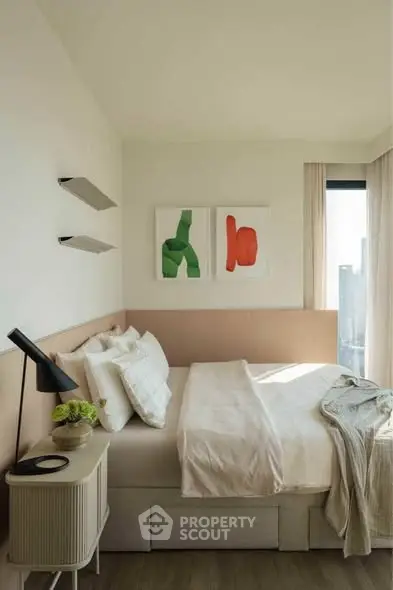 Modern bedroom with stylish decor and large window offering city views, featuring minimalist furniture and art.
