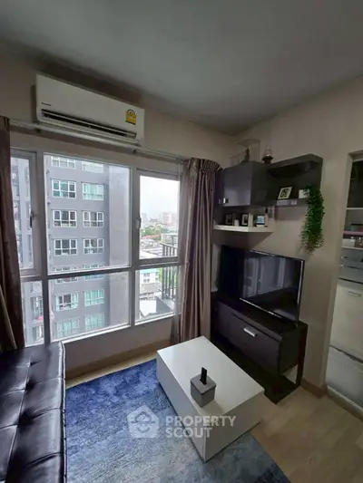 Modern living room with city view, featuring sleek furniture and large windows for natural light.