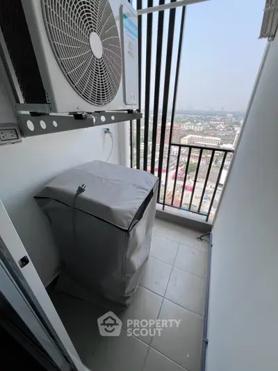 Compact balcony with city view, featuring air conditioning unit and covered appliance, ideal for urban living.