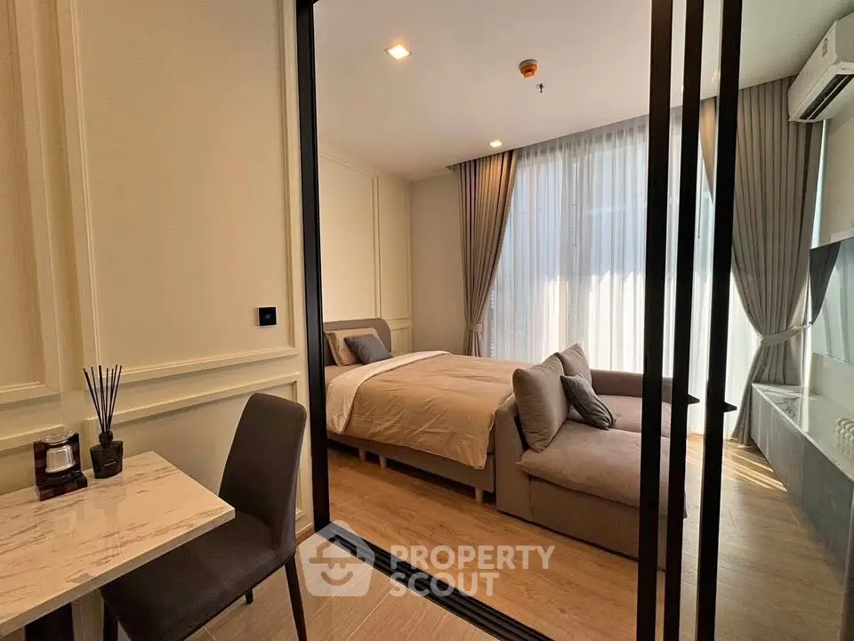 Modern bedroom with elegant decor and natural light, featuring a cozy bed and stylish furniture.
