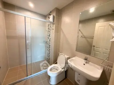 Modern bathroom with glass shower and sleek fixtures in a contemporary home.