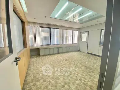 Spacious office room with large windows and modern lighting
