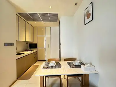 Modern kitchen with dining area, sleek cabinetry, and elegant decor in a contemporary apartment.