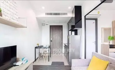 Modern apartment interior with open layout, featuring cozy living area and compact kitchen.