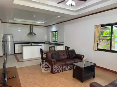 Spacious open-plan living room with modern kitchen and cozy seating area.