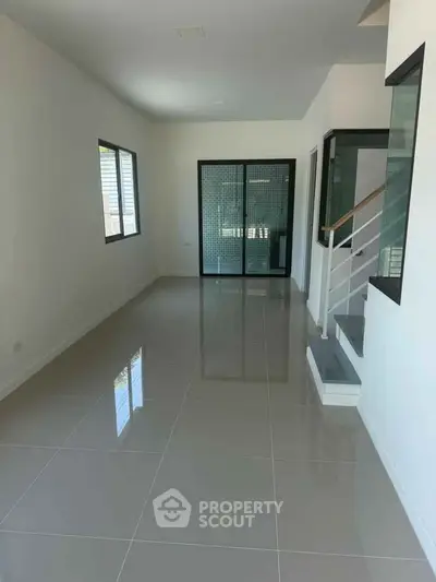 Spacious modern hallway with glossy tiled floors and large windows