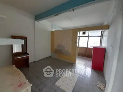 Spacious room with potential for renovation, featuring large windows and ample natural light.