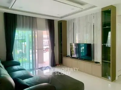 Modern living room with sleek TV unit and large windows for natural light.
