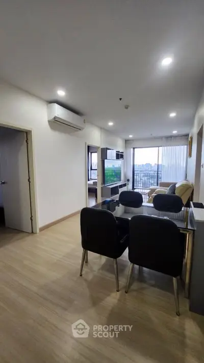 Modern open-plan living room with dining area and city view balcony