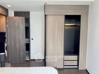 Modern bedroom with sleek wooden wardrobe and minimalist design