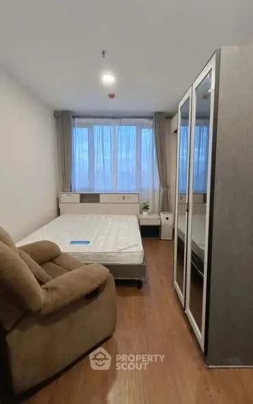 Cozy bedroom with large mirrored wardrobe and comfortable armchair