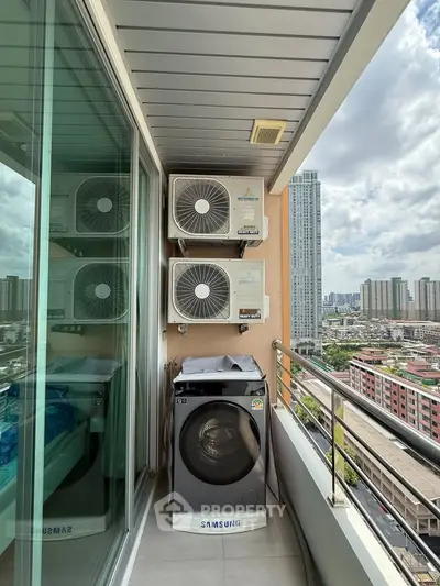 High-rise balcony with city view, featuring washing machine and air conditioning units.