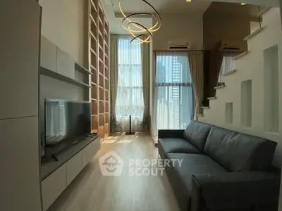 Modern living room with high ceilings, large windows, and stylish lighting in a contemporary apartment.