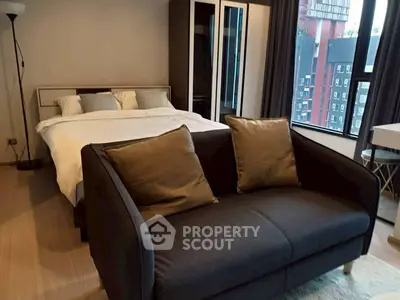 Modern bedroom with cozy sofa and large window view in stylish apartment