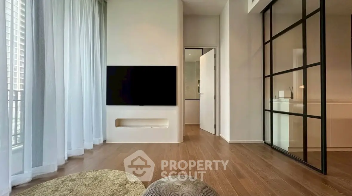 Modern living room with sleek design, large windows, and wooden flooring in a stylish apartment.