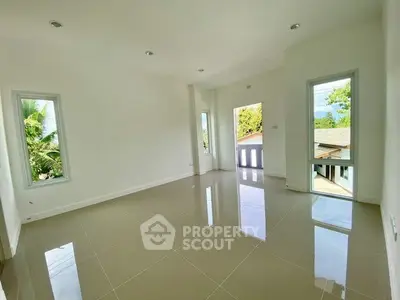 Spacious and bright empty room with glossy tiled floors and large windows offering lush green views.