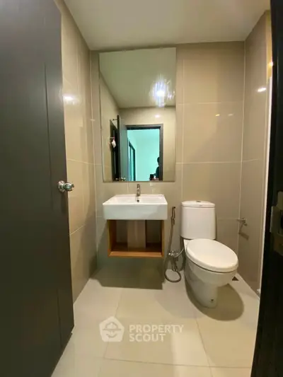 Modern bathroom with sleek fixtures and large mirror in a contemporary apartment.