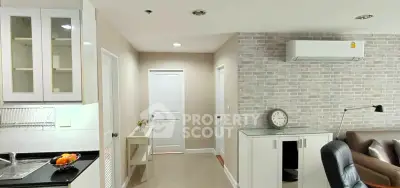 Modern apartment interior with sleek kitchen and cozy living area, featuring stylish decor and efficient layout.